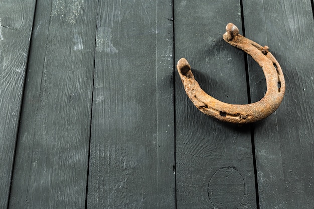 Old rusty horseshoes on wooden board