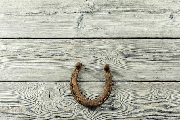 Old rusty horseshoes on wooden board