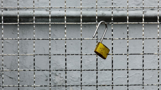 Old and rusty key at steel fence