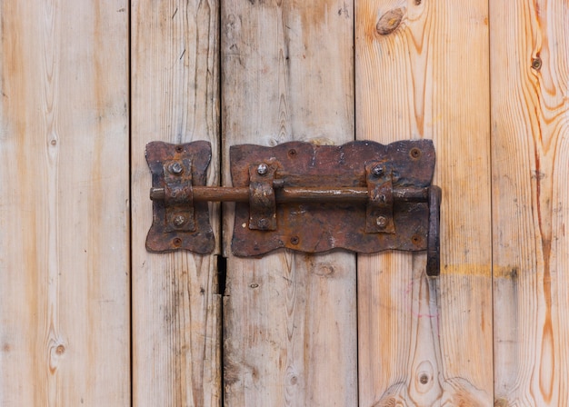 나무 문에 오래 된 녹슨 자물쇠