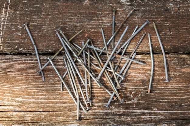 Old rusty nails on wooden background. Nails on wooden table