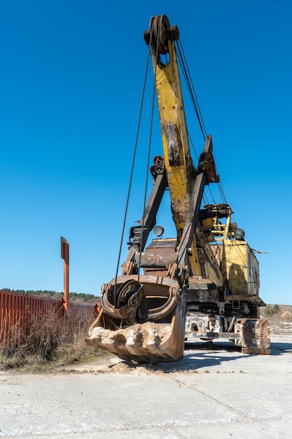 An old rusty quarry excavator is located on the territory of a\
mining quarry an open method of mining