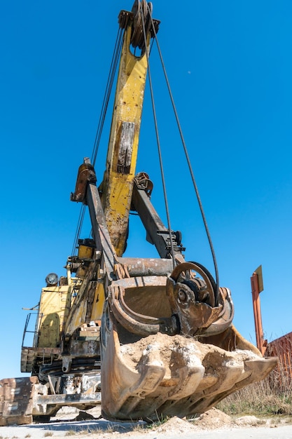 An old rusty quarry excavator is located on the territory of a mining quarry an open method of mining