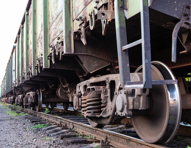 Old rusty railway cars stand on the tracks of the station