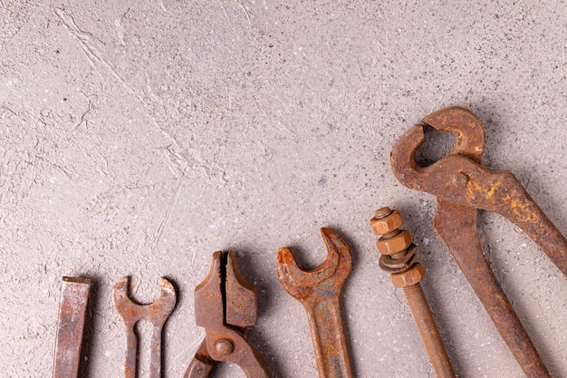 Old rusty rural tools lie on a gray background, close-up