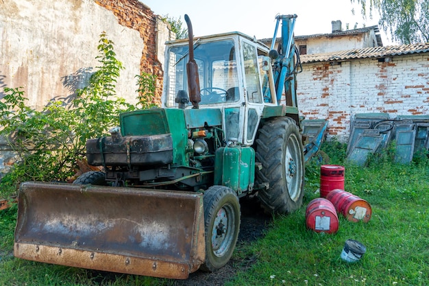 An old rusty Sovietera tractor is parked on a farm plot Repair of agricultural machinery Poor regions of Russia Lack of financing of private farms