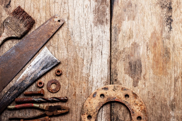 Old rusty tools on old wood background.