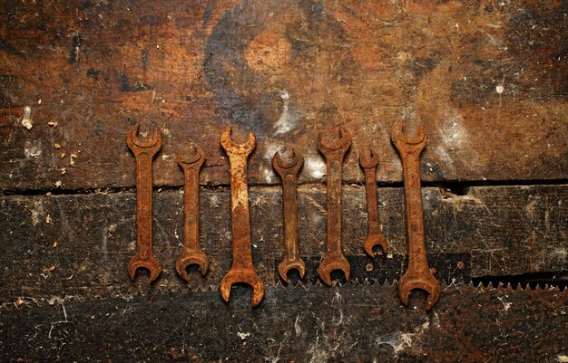 Old rusty wrench on dirty wooden table