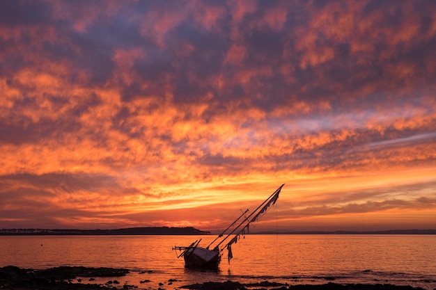 Old sailboat stranded in front of Gorriti Island during sunset