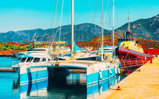 Old Sardinian Port and marina with ships at Mediterranean Sea in city of Villasimius in South Sardinia Island Italy in summer. Cityscape with Yachts and boats