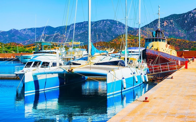 Old Sardinian Port and marina with ships at Mediterranean Sea in city of Villasimius in South Sardinia Island Italy in summer. Cityscape with Yachts and boats