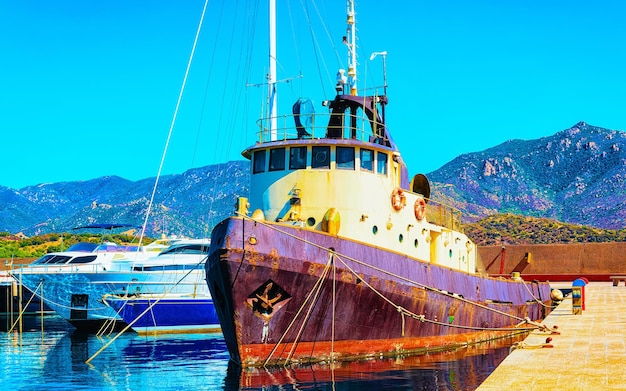 Старый сардинский порт и пристань для яхт с кораблями в Средиземном море в городе Вилласимиус на острове Южная Сардиния Италия летом. Городской пейзаж с яхтами и лодками