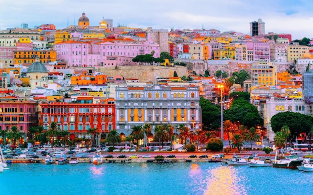 Old Sardinian Port with ships at Mediterranean Sea and city of Cagliari, South Sardinia Island in Italy in summer. Cityscape with marina and Yachts and boats in town