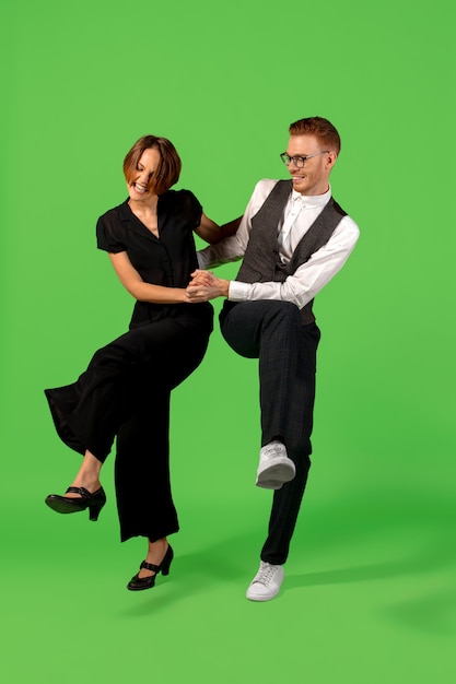 Old-school fashioned young woman dancing isolated on green background