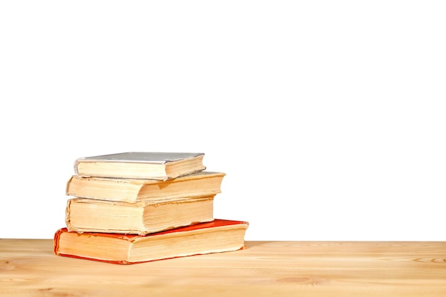 Old schoolbooks lying on a wooden school desk in front on a white background Education concept the desk in the auditorium back to school concept