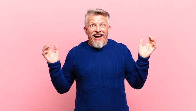 Photo old senior man feeling happy, excited, surprised or shocked, smiling and astonished at something unbelievable