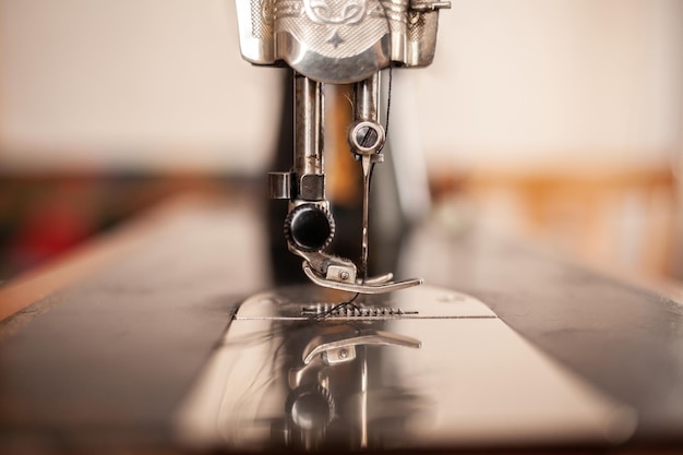 An old sewing machine stands on the table at home ready to work and sew Classic retro style manual