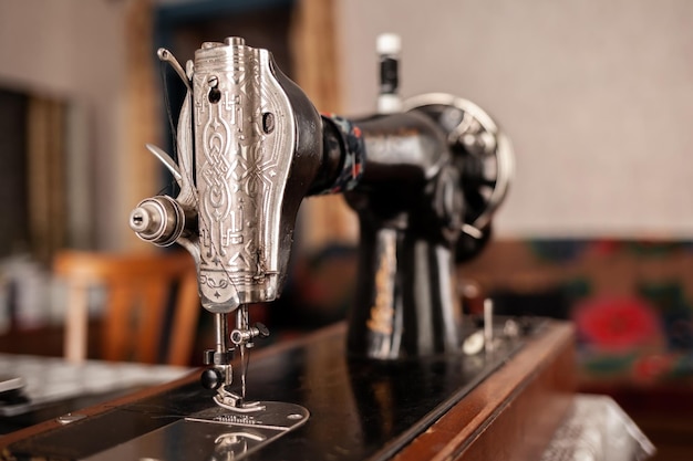 An old sewing machine stands on the table at home ready to work and sew Classic retro style