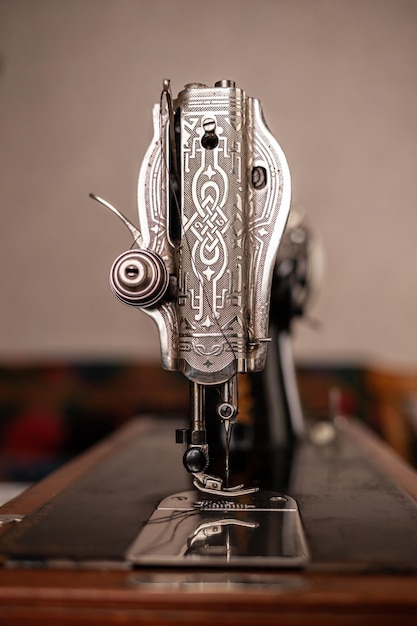 An old sewing machine stands on the table at home ready to work and sew and sewing work.