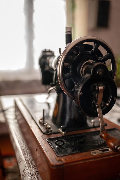 Old sewing machine stands on the table at home ready to work and sew