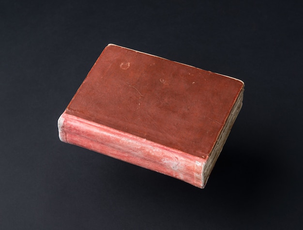 Old shabby book on a black background. ancient handwritten book