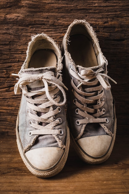 Foto vecchie scarpe da ginnastica su fondo in legno