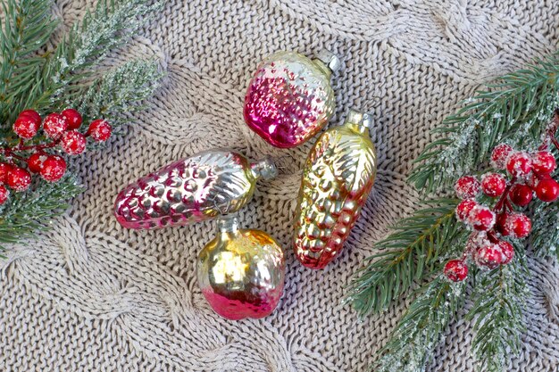 Old soviet decoration on the Christmas tree glass toy strawberry and pine cone close up on knitted background