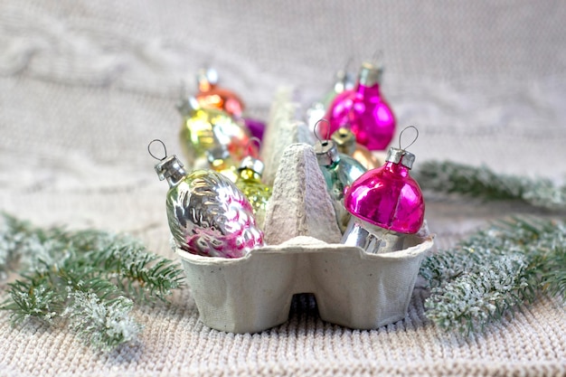 Old soviet decoration on the Christmas tree glass toy strawberry and pine cone close up on knitted background