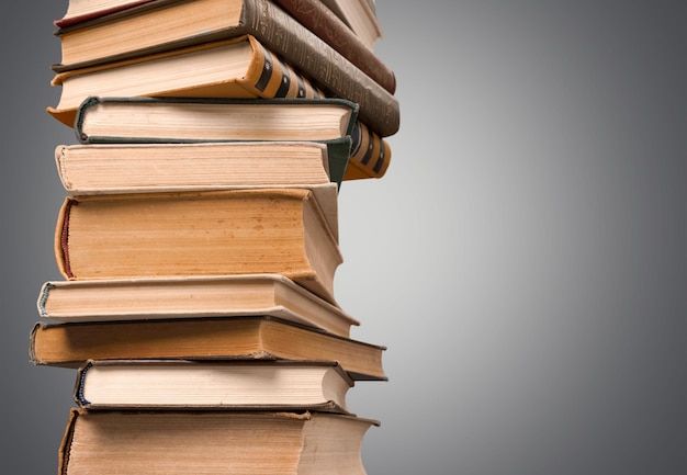 Old stacked books on table background