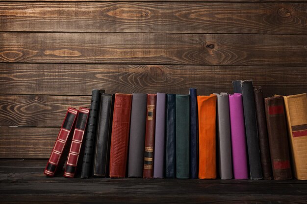 Vecchi libri impilati su fondo di legno
