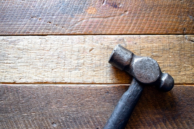 Old steel hammer on wood background. top view. flat lay