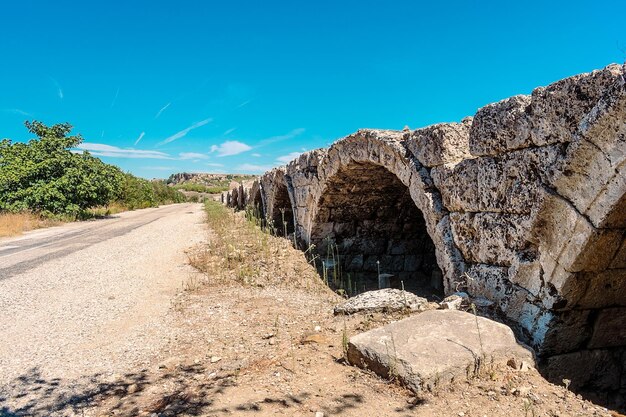 the old stone bridge is a stone arch that is built into the side of a dirt road