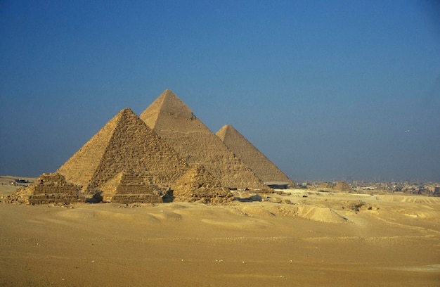 old stone pyramids on desert landscape against clear sky