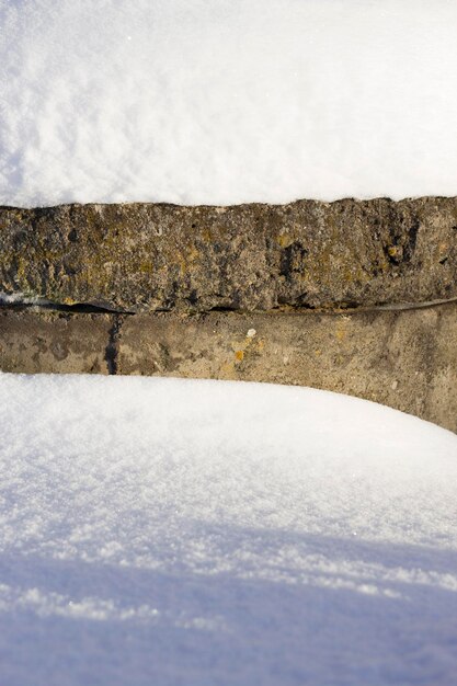 写真 晴れた冬の日に大きな雪が漂う古い石の壁