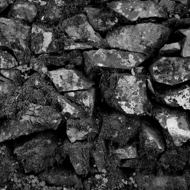 古代の壁に組み合わせられた古い石黒と白の正方形のストック写真