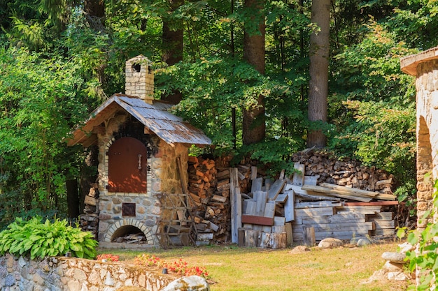 Foto una vecchia stufa e legna da ardere per essa nel cortile del villaggio