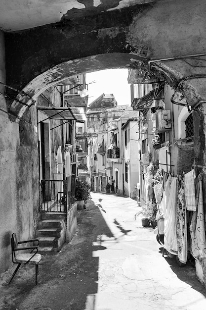 Old street with dilapidated houses in Catania, Sicily, Italy. Black and white image