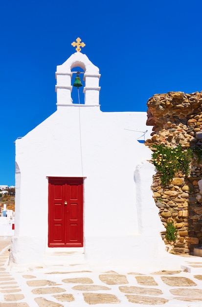 Old street with white ancient greek church in Mykonos town (Chora), Greece