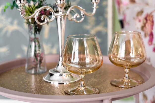 Old style retro candles and wine glass on a tray vintage home decor on an a table in light tones