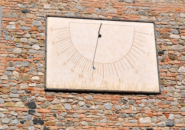 Old sundial on a red bricks wall