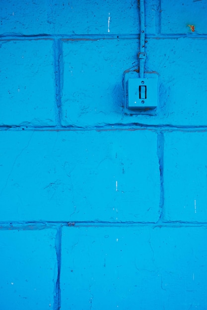 The old switch in the web on the blue brick wall