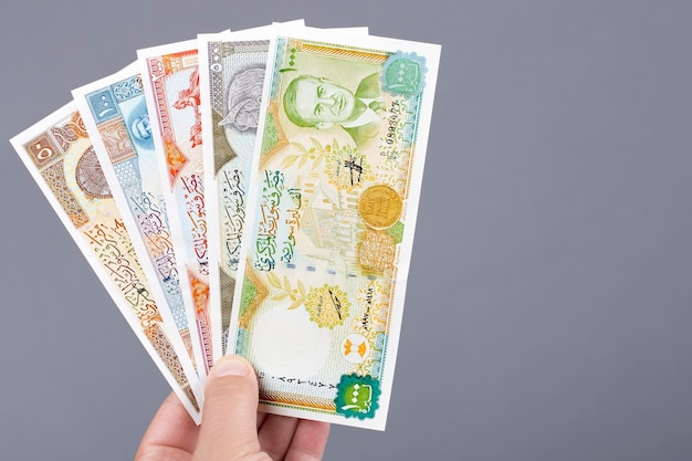 Old Syrian money in the hand on a gray background