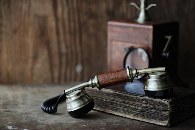 Old telephone and retro book on a wood