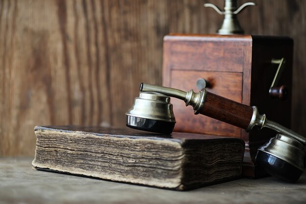 Old telephone and retro book on a wooden table