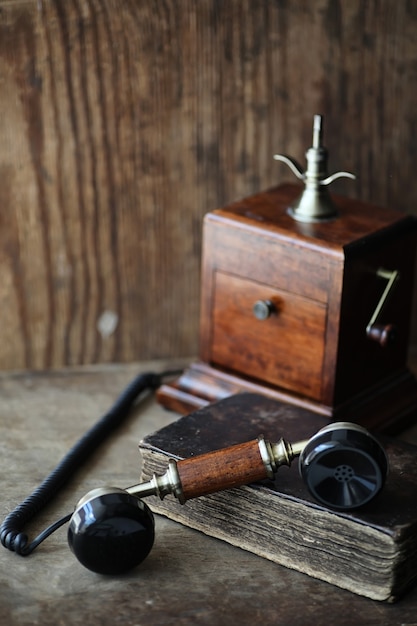 Old telephone and retro book on a wooden table