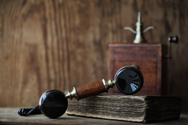 Old telephone and retro book on a wooden table