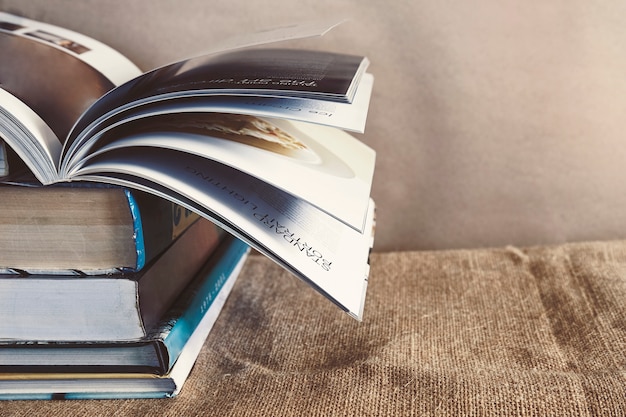 Old textbook stack on the sackcloth with the book turning pages on top