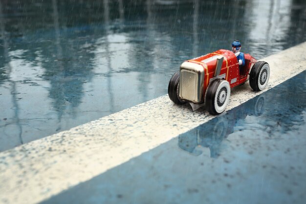 Old tin toy model racer in the rain.