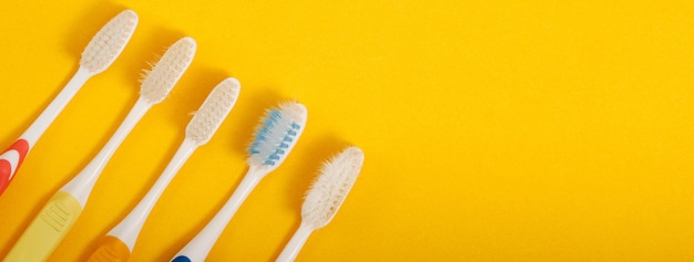 Old toothbrush on yellow background