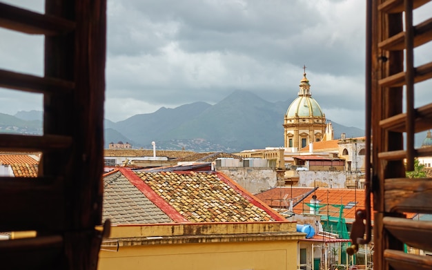 The old town of Palermo in Sicily through the open window with shutters, Italy